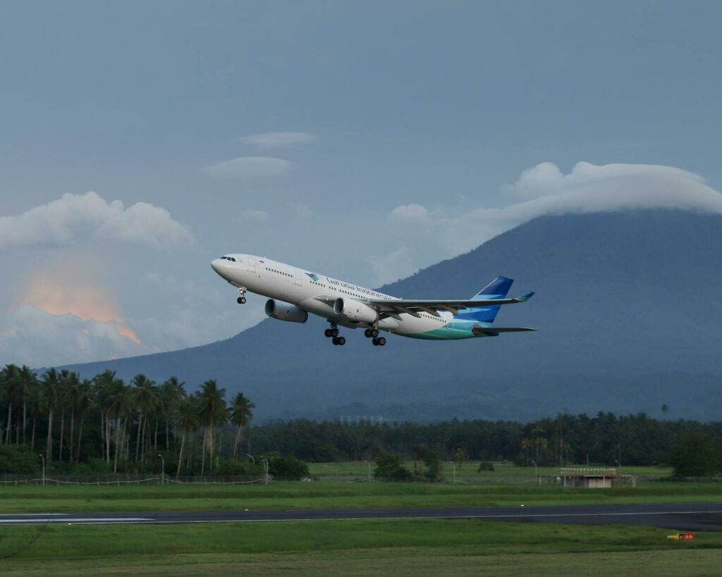 An airplane takes off against a mountain backdrop in Manado, Indonesia.