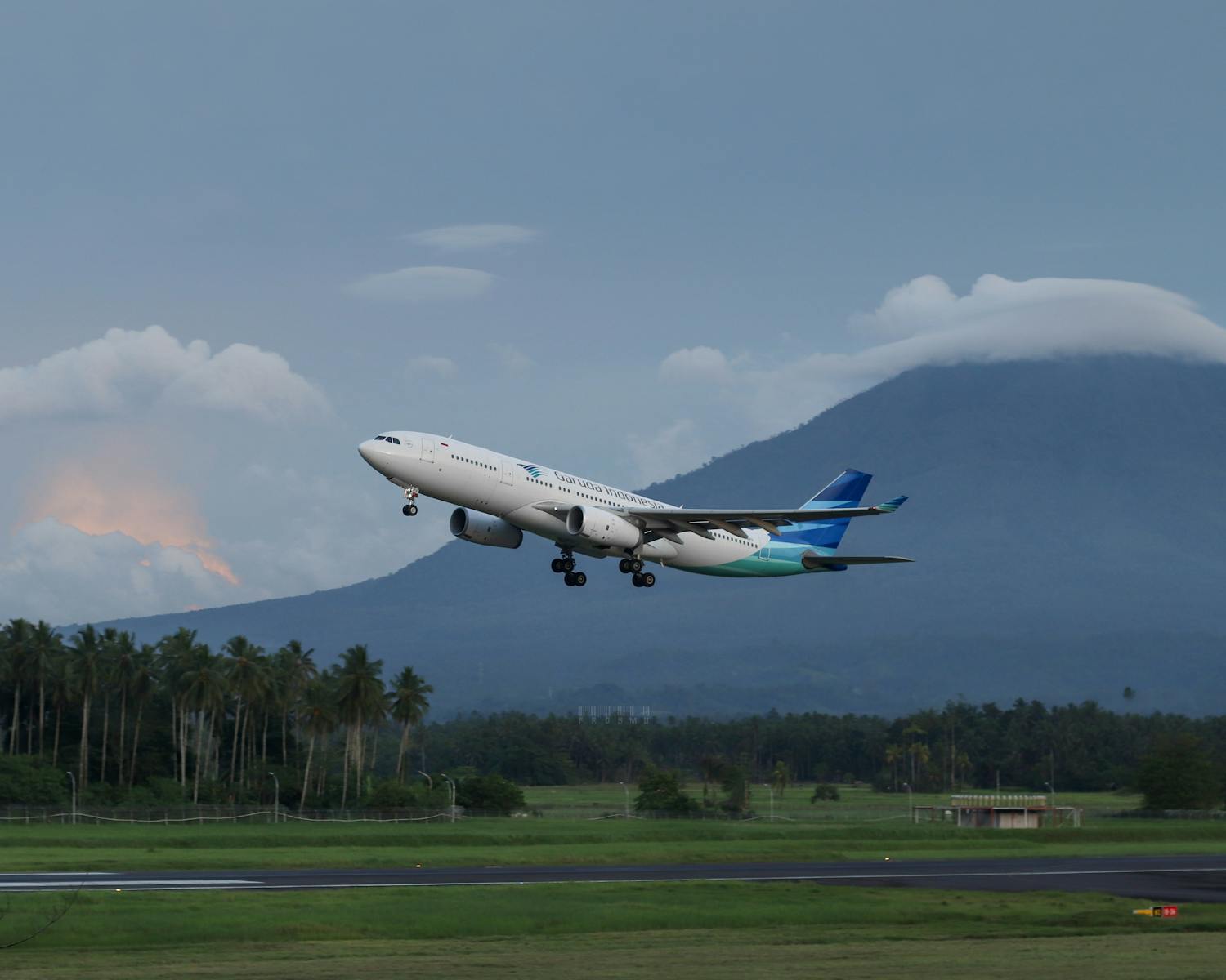 An airplane takes off against a mountain backdrop in Manado, Indonesia.